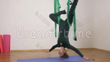 年轻的白种人妇女在<strong>室内</strong>工作室的<strong>吊床</strong>上做反重力飞行瑜伽练习。 航空飞行健身